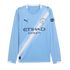 Long-sleeved light blue Manchester City Puma soccer jersey featuring a diagonal white sash, the club crest, and Etihad Airways sponsor logo.