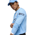 A man in a light blue Manchester City long-sleeve jersey and matching cap, posing against a white background.