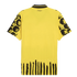 Back of a yellow jersey featuring black-patterned sleeves, vertical stripes at the hem, and 'KidSuper' text near the collar. Small Puma logos are visible on the shoulders.