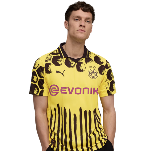 A man wearing a yellow and black Borussia Dortmund soccer jersey with animal-print spots and vertical stripes, featuring the Evonik sponsor logo, against a white background.