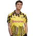 A man wearing a yellow and black Borussia Dortmund soccer jersey with animal-print spots and vertical stripes, featuring the Evonik sponsor logo, against a white background.