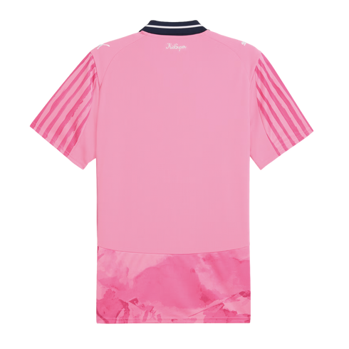 Back view of a pink short-sleeved jersey with a dark blue collar, vertical stripes on sleeves, "KidSuper" text, and a marbled pink pattern at the bottom hem.