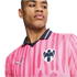 A man wearing a pink C.F. Monterrey soccer jersey with dark pink stripes, a navy collar, and the team crest, looking to the side against a white background.