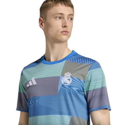 Man wearing a blue and green patterned Real Madrid soccer jersey with the Adidas logo.
