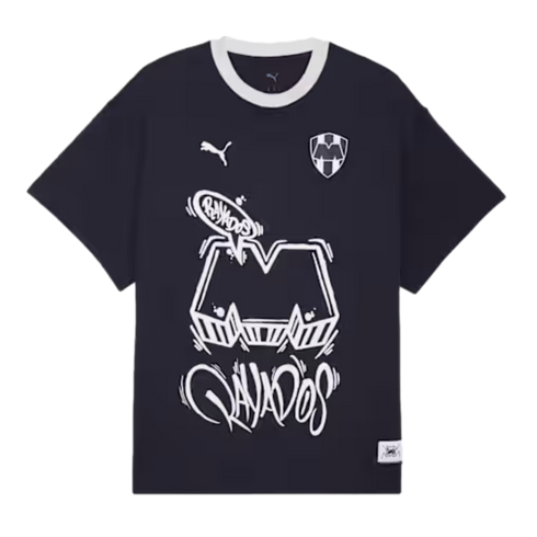 Black Puma Rayados t-shirt with white graffiti-style "M" and "Rayados" graphics. Features the team crest and a white crew neck.