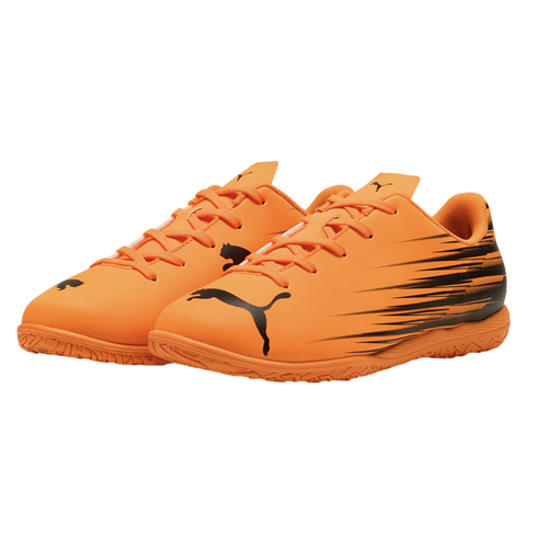 Pair of bright orange Puma indoor soccer shoes with black graphic details and logos, set against a black background.