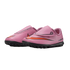 A pair of pink Nike Mercurial kids' soccer shoes with orange swooshes and black studded soles, featuring velcro strap closures, shown against a black background.