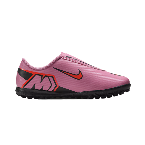A pink Nike Mercurial turf soccer shoe featuring a black swoosh with a red outline and a stylized "M" logo on the heel.