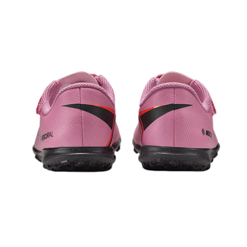 Rear view of pink Nike Mercurial turf soccer shoes with black soles, isolated on a black background.
