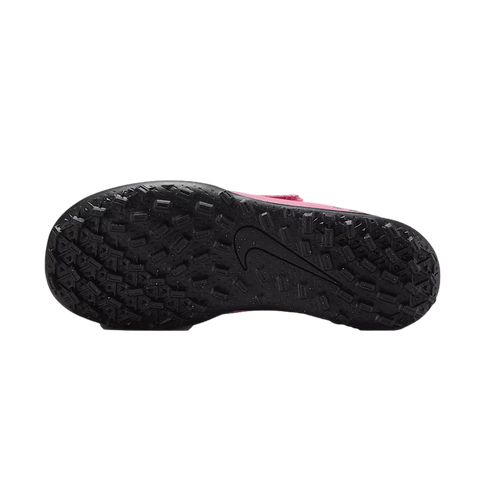 Bottom view of a black studded outsole of a pink Nike turf soccer shoe with a large Nike swoosh logo in the center.