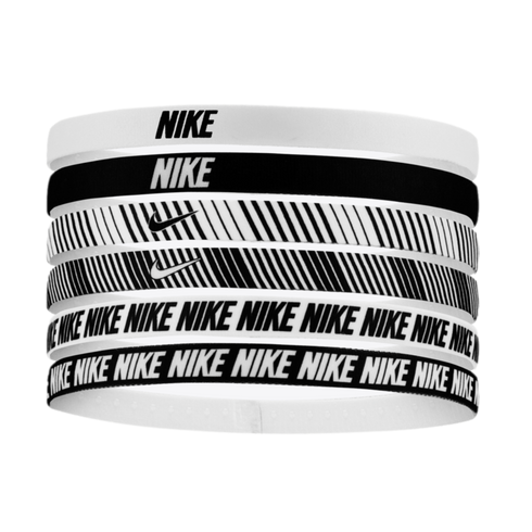 Six Nike headbands stacked vertically. Designs include solid colors with logos, diagonal stripes with swooshes, and repeating 'NIKE' patterns in black and white.