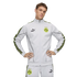 A man in a light grey Puma BVB 09 tracksuit with yellow patterned side stripes, posing against a black background with hands on his hips.