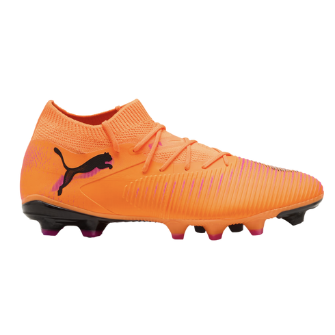 Bright orange Puma soccer boot with a black cat logo, textured upper, and sock-like collar. It features a black sole with pink-tipped studs, set against a black background.