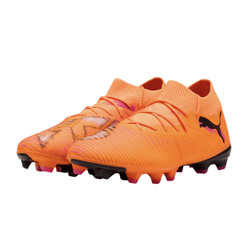 Bright orange Puma soccer cleats with pink and black accents, featuring a textured upper and knitted collar, isolated on a black background.