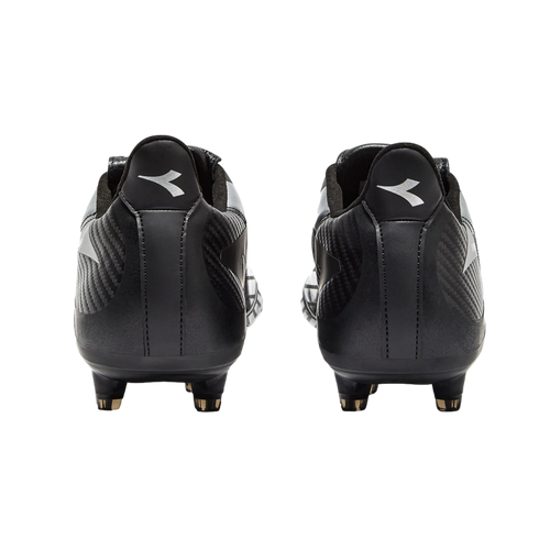 A rear view of black Diadora soccer cleats against a black background, with the white brand logo visible on each heel.