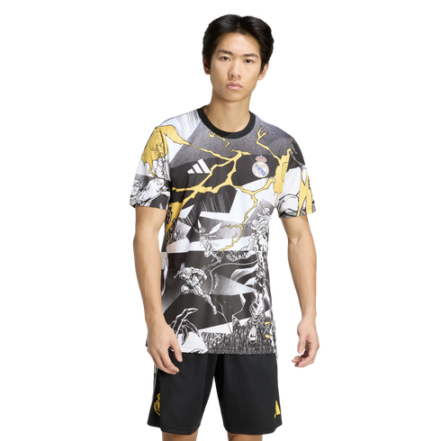 Man in a black, white, and yellow Real Madrid x Marvel graphic tee and black shorts against a solid black background.