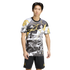Man in a black, white, and yellow Real Madrid x Marvel graphic tee and black shorts against a solid black background.