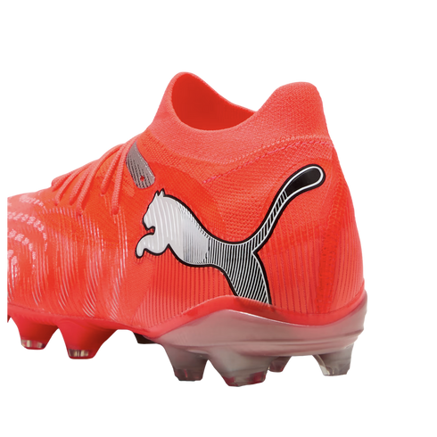 Vibrant orange Puma soccer boot with a silver logo and clear studs, shown from a rear side angle on a black background.