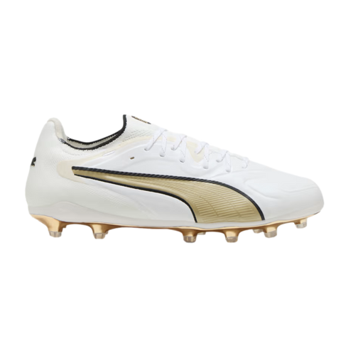 White Puma soccer cleat with a gold and black Formstrip and gold-studded soleplate, shown from a side profile.