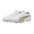 A pair of white Puma soccer cleats with gold logos and matching gold studs, displayed against a black background.