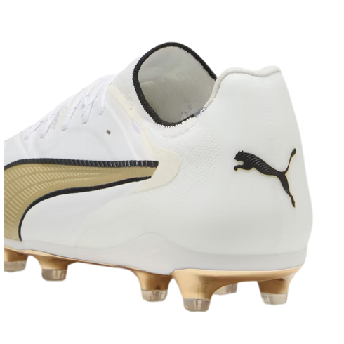 A white Puma soccer cleat featuring a metallic gold soleplate with clear studs, a black leaping cat logo on the heel, and gold and black accents on the side.