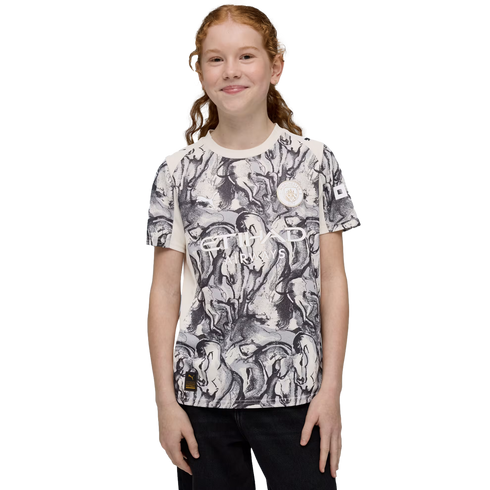 A smiling girl with red hair wears a Manchester City Etihad Airways t-shirt featuring a black and white graphic print against a black background.