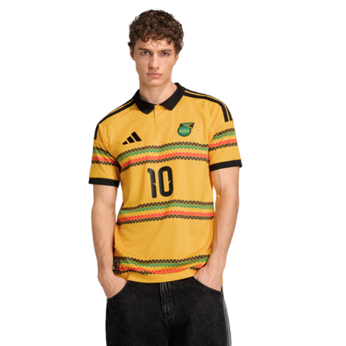 Man in a yellow Adidas Jamaica jersey with number 10 and black, red, and green patterned stripes, against a black background.