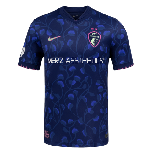 Navy soccer jersey with blue Venus flytrap patterns, white Merz Aesthetics text, a pink Nike swoosh, and NC Courage crest. Jagged pink trim lines the sleeve cuffs and bottom hem.