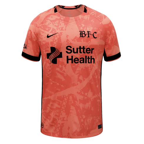 Peach soccer jersey with an abstract pattern and black Nike, 'B.F.C' gothic, and Sutter Health logos. Black trim on collar and sleeves.