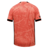 Back view of a salmon-pink jersey with an abstract tonal pattern, black sleeve cuffs, and thin black side stripes on a black background.
