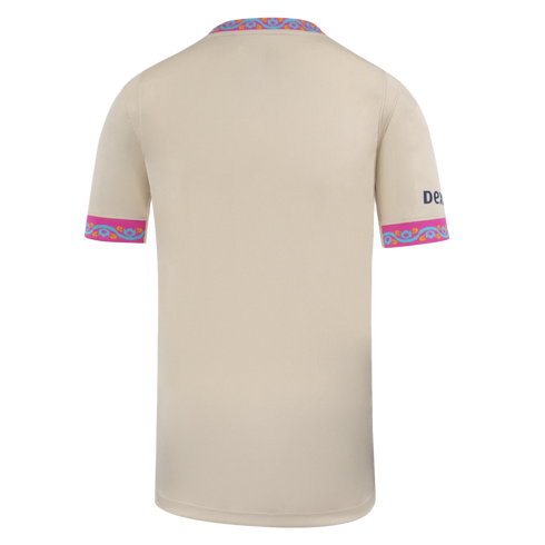 Back of a beige jersey with pink and turquoise patterned trim on the collar and cuffs, featuring a small blue logo on the right sleeve.