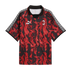AC Milan x Puma King soccer jersey featuring a red and black flame pattern, black polo collar, and white geometric shoulder stripes.
