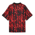 Back view of a short-sleeved polo shirt with a black and red flame pattern and a black collar with red trim.