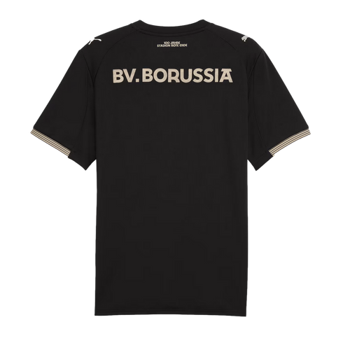 Back of a black football jersey with "BV. BORUSSIA" in large cream vintage font. Small anniversary text sits above it, with striped sleeve cuffs and a Puma logo on the shoulder.