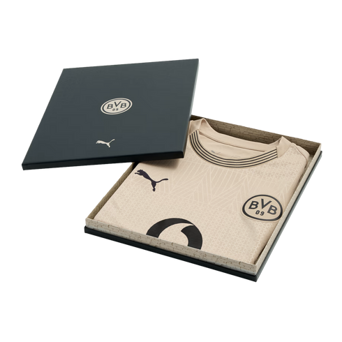 A tan Puma BVB 09 soccer jersey with black logos and trim, presented in a dark grey gift box.