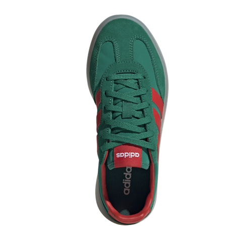 A top-down view of a single green Adidas sneaker with red accents and green laces, set against a black background.