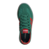 A top-down view of a single green Adidas sneaker with red accents and green laces, set against a black background.