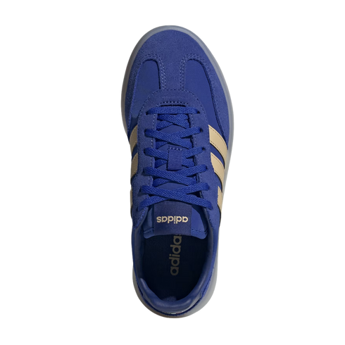 A top-down view of a royal blue Adidas sneaker with tan stripes and blue laces, set against a solid black background.