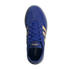 A top-down view of a royal blue Adidas sneaker with tan stripes and blue laces, set against a solid black background.