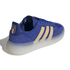 A blue suede and mesh sneaker with three cream-colored stripes and a thick, translucent white sole. The heel tab features the Italian national football team (FIGC) crest with four gold stars above it.