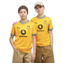 Two young people pose side-by-side in matching yellow Borussia Dortmund soccer jerseys against a black background. One wears a brown bandana and the other a beige baseball cap.