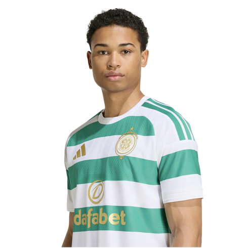 A young man wearing a green and white striped Celtic FC soccer jersey with gold logos against a plain white background.