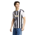 A smiling man wearing a Juventus black and white striped football jersey with gold accents and blue jeans, against a white background.