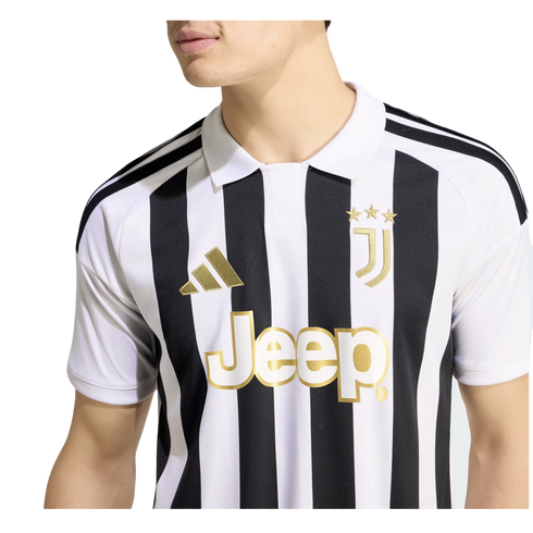 A person wearing a black and white striped Juventus home jersey with gold-toned logos and a white polo collar.