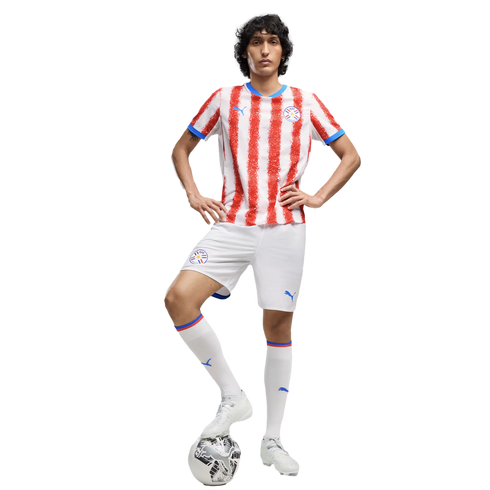A man in a red and white striped Paraguay national team soccer uniform posing with a soccer ball against a white background.