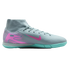 Grey Nike indoor soccer shoe with a pink swoosh and heel graphic, featuring a high-top sock-like collar and a turquoise flat rubber sole.