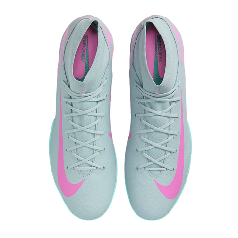 Top-down view of grey Nike Mercurial soccer shoes with pink Nike swooshes and teal accents along the soles.