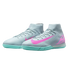 Light grey Nike indoor soccer shoes with turquoise soles and bright pink swooshes. Features a high-top sock collar and textured upper.