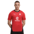 Man in a red Puma soccer jersey with white eFootball and Puma logos, featuring a black collar and side panels, against a black background.