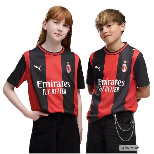 A red-haired girl and a blonde boy pose side-by-side in matching red and black AC Milan football jerseys against a plain white background.